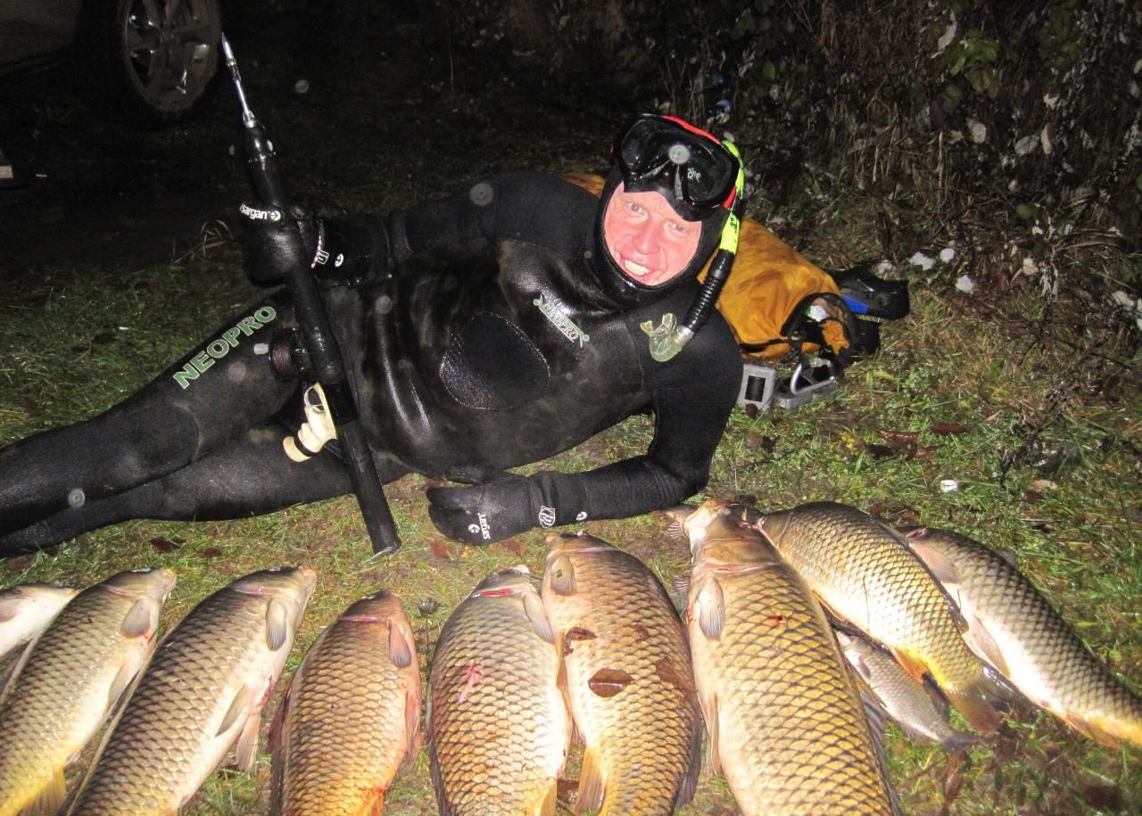 Охотник в подводном костюме с кучей рыб