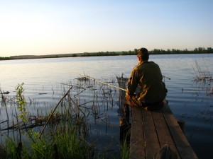 Мужчина рыбачит на озере