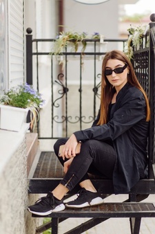 Веселая красивая брюнетка женщина в хорошем настроении пользуется телефоном на улице