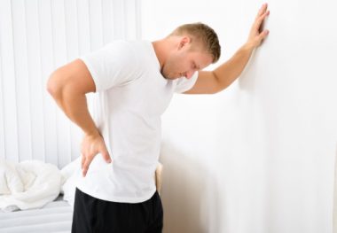 Мужчина держится за стену