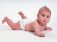 Младенец в памперсе лежит на животике